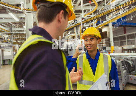 Workers talking in factory Stock Photo