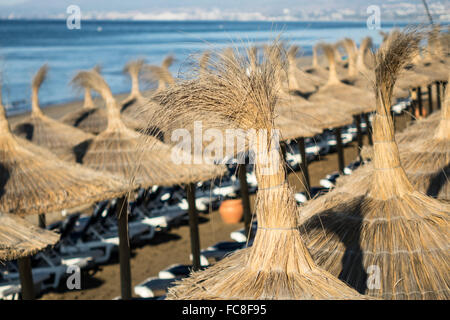 Sun shades above loungers on beach Stock Photo