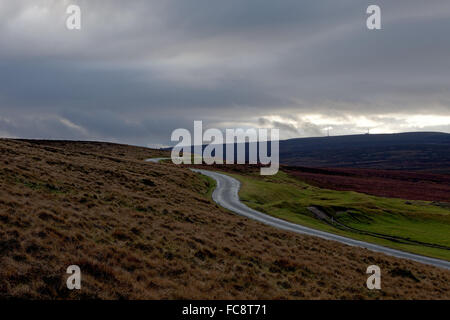 landscape photograph of an isolated hilltop winding road under cloudy sky. Stock Photo