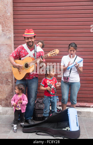 Street musician and his family playing music in Quito, Ecuador. Stock Photo