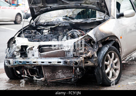 London, UK, 21 January 2016. A Ford car caught fire outside Tesco Express on Wood Green High Road early this morning.  Smoke still coming though the burned engine and the font of the car. Police cordoned off the burned out car with police tape. Credit:  Dinendra Haria/Alamy Live News Stock Photo