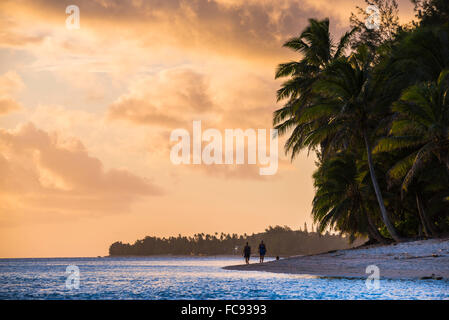 Walking along a tropical beach at sunset, Rarotonga, Cook Islands, South Pacific, Pacific Stock Photo