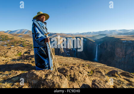 A local sheep shepherd converges on the cliffs of Maletsunyane Falls in rural Lesotho. Stock Photo