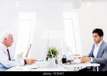 Two businessmen in fornt of their computers in office Stock Photo - Alamy