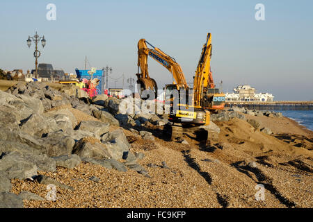 heavy plant machinery placing boulders to repair storm damaged promenade at southsea england uk Stock Photo