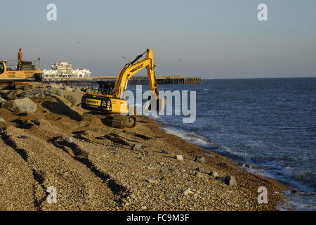 heavy plant machinery placing boulders to repair storm damaged promenade at southsea england uk Stock Photo