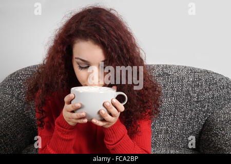 girl sipping from large cup of coffee Stock Photo