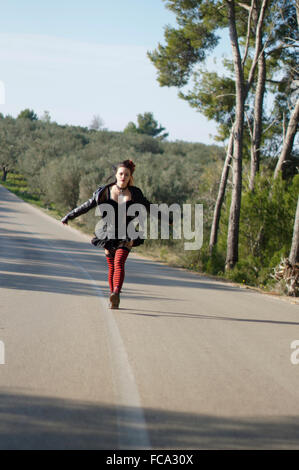 Girl running on the road Stock Photo