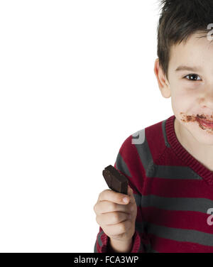 Smiling little boy eating chocolate Stock Photo