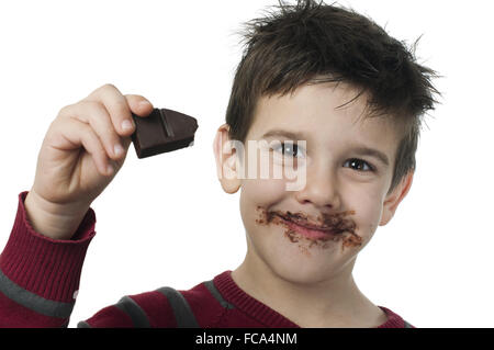 Smiling little boy eating chocolate Stock Photo