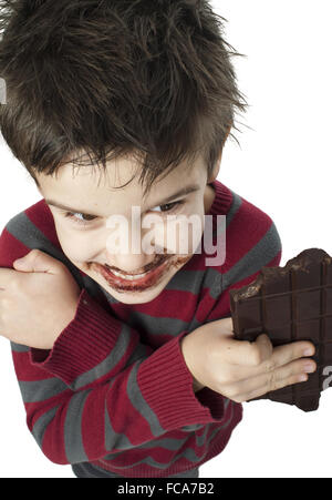 Smiling little boy eating chocolate Stock Photo