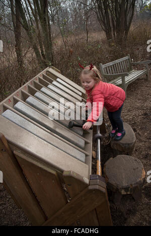 A child playing a xylophone while visiting the Everett Children's Adventure Garden within the New York Botanic Gardens NYC  USA Stock Photo