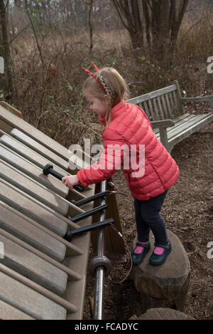 A child playing a xylophone while visiting the Everett Children's Adventure Garden within the New York Botanic Gardens NYC  USA Stock Photo