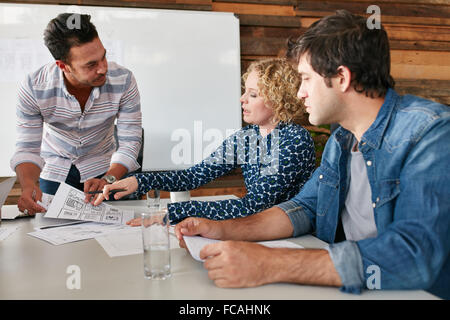 Young man and woman doing discussion at table during a meeting in office. Creative team planning new business strategy. Stock Photo