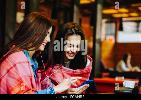 Two girl sitting listening music Stock Photo