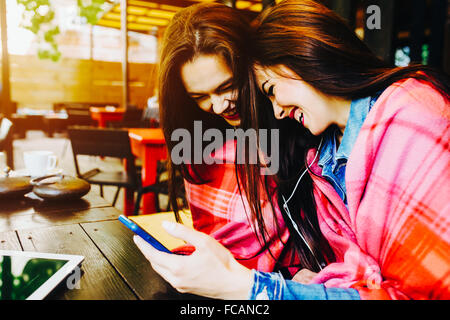 Two girl sitting listening music Stock Photo