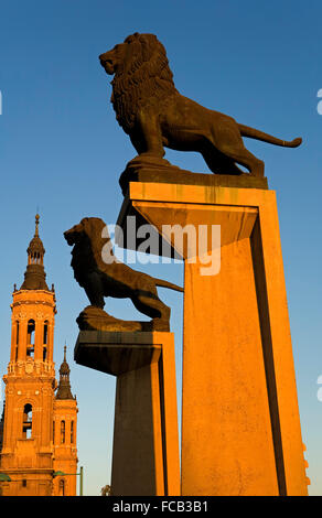 Zaragoza, Aragón, Spain: Lions at the entrance to bridge 'de piedra', with the towers of El Pilar Stock Photo