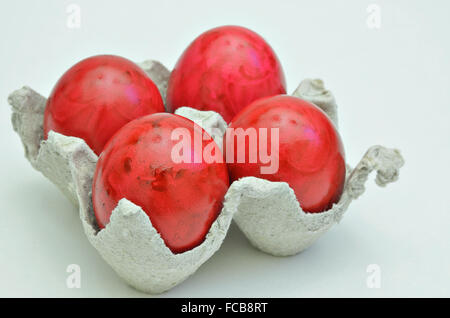 four red Easter eggs in a cardboard box, close up, isolated on  white background, horizontal Stock Photo