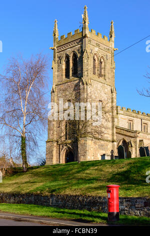 St Mary's Parish Church Wymeswold with a traditional red British pillar box postbox in front. On 15th January 2016, Wymeswold. Stock Photo