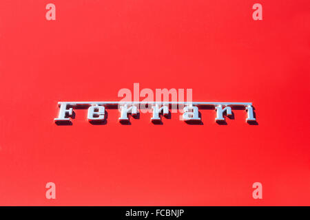 Silver Ferrari logo on red metal car body Stock Photo