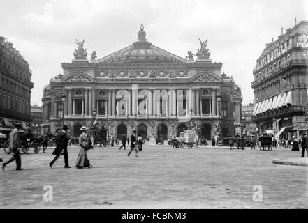 AJAXNETPHOTO. 1900. PARIS, FRANCE. - PALAIS GARNIER - PEDESTRIANS CROSSING THE SQUARE IN FRONT OF THE THE OPERA - L'OPERA - IN THE DAYS OF HORSE DRAWN TRAFFIC AND BARROW BOYS.  PHOTO:AJAX VINTAGE PICTURE LIBRARY  REF:PARIS L'OPERA 1900 Stock Photo