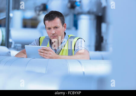 Worker using digital tablet in factory Stock Photo