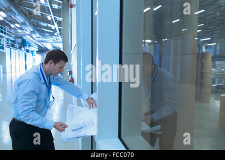 Engineer reviewing blueprints in factory Stock Photo