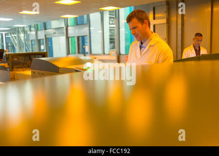 Workers among printers in printing plant Stock Photo