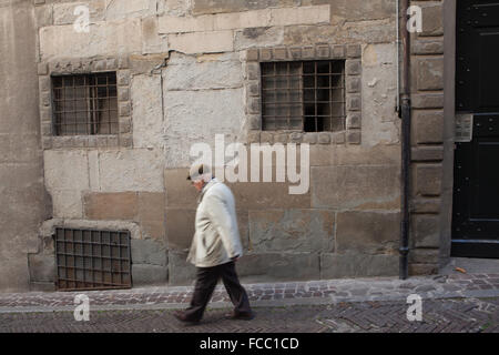 Elderly man walking down along the medieval street in the Citta Alta (Upper Town) in Bergamo, Lombardy, Italy. Stock Photo