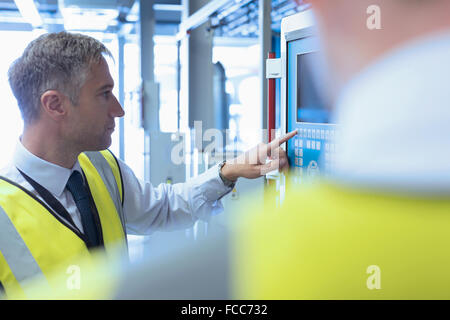 Workers at control panel in factory Stock Photo