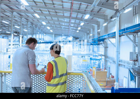 Workers with digital tablet on platform above factory Stock Photo