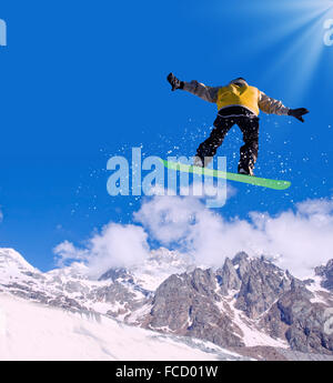 Snowboarder making jump high in clear sky Stock Photo