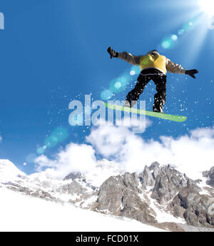 Snowboarder making jump high in clear sky Stock Photo