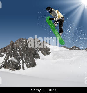 Snowboarder making jump high in clear sky Stock Photo