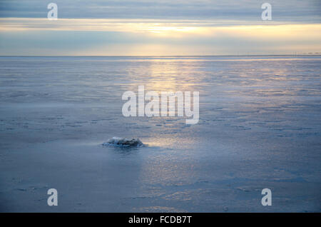Reflections from the setting sun at an icebound lake Stock Photo