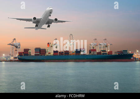 Industrial Container Cargo freight ship with working crane bridge in shipyard at dusk for Logistic Import Export background Stock Photo