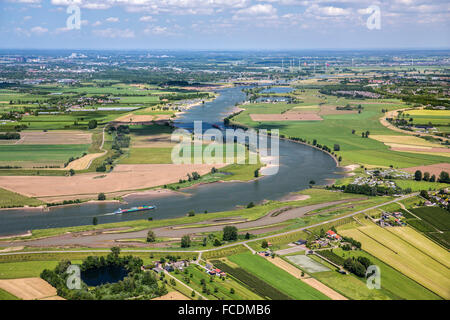 Netherlands, Lexmond, Cargo boat in river Lek. Aerial Stock Photo