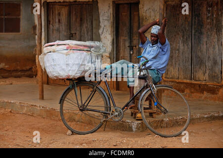 Stone Town (Zanzibar), Tanzania  - January 10, 2016: A adult man with a bike on background old wall in Stone Town, Zanzibar. Stock Photo