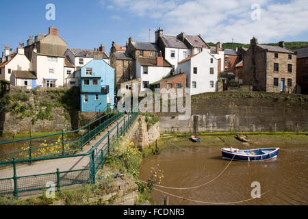 Footbridge across river in Picturesque fishing village by sea in Staithes Yorkshire Stock Photo