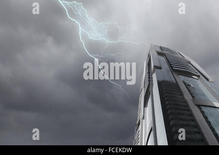 Bottom image of skyscraper with thunder lightning in sky Stock Photo