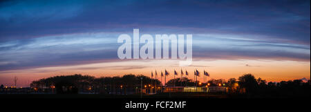 Flag Plaza's American banners flapping in the wind against a background of deep blue clouds at sunset near Jersey City, NJ. Stock Photo