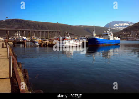 Boats in the harbour at Skansen Docks with Tromsø Bridge in the background,Norway Scandinavia Europe Stock Photo