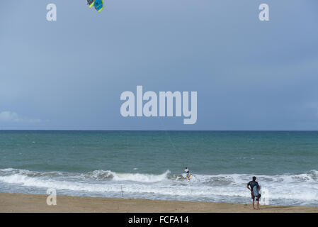 Surfer observing a kitesurfer in the water. Dorado, Puerto Rico. Caribbean Island. US territory. Stock Photo