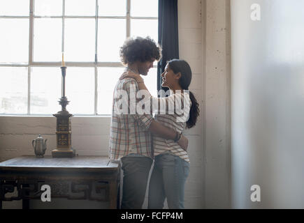 Loft living. A couple facing each other embracing. Stock Photo