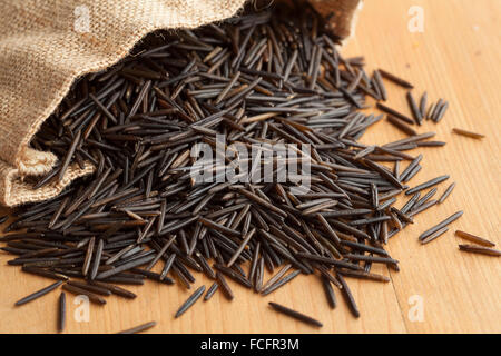 Raw black wild rice from a jute bag Stock Photo