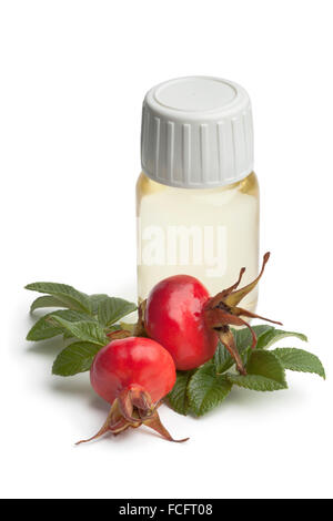 Bottle rose hip oil and fresh rose hips on white background Stock Photo