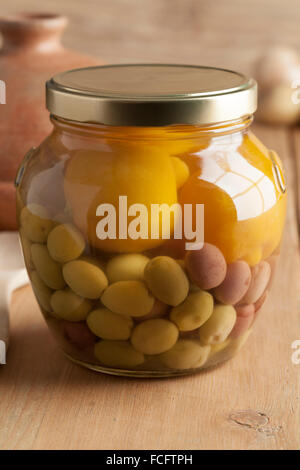 Moroccan glass jar with preserved olives and lemons Stock Photo