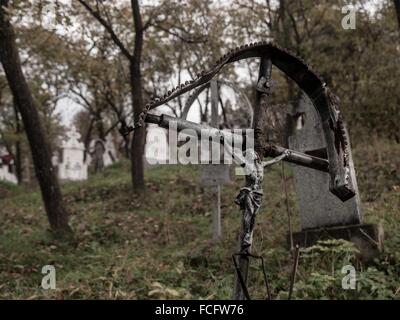 Metal cross with Jesus as grave marker at Poienile Izei cemetery in Maramures region, Romania, Europe. Stock Photo