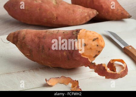 Partially peeled fresh sweet potato Stock Photo