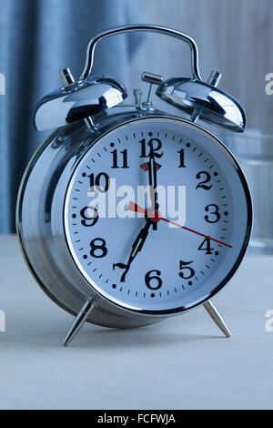 Traditional alarm clock at seven o'clock in the morning Stock Photo